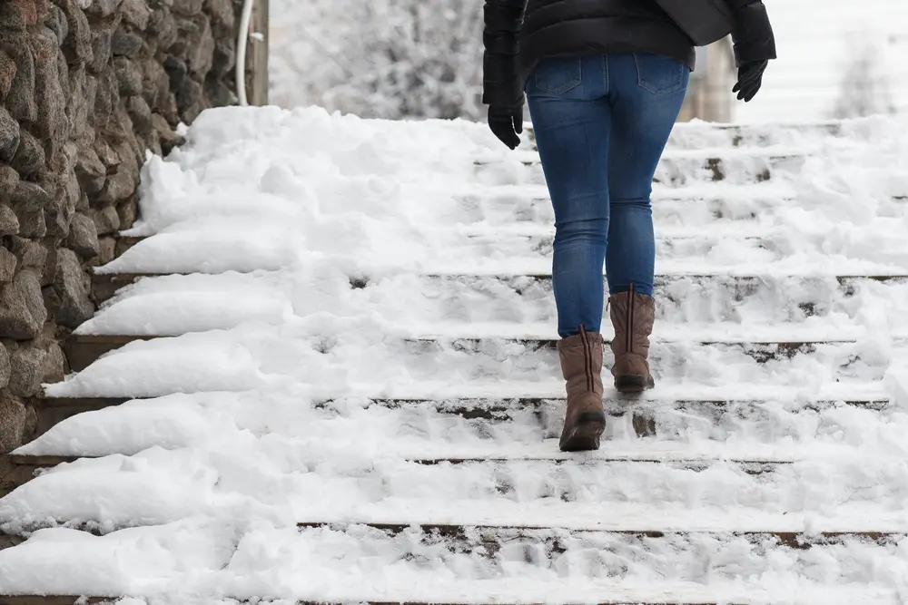 Woman walking up icy stairs