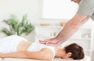 chiropractor adjusting female patients upper back