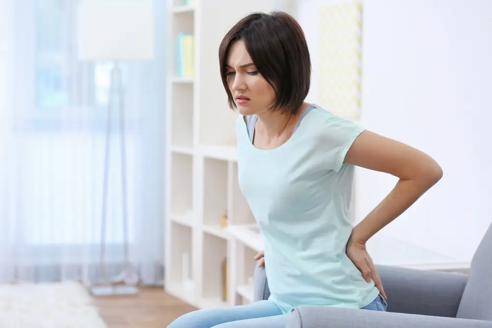 Woman with back pain seeks treatment at Kosak chiropractic in Omaha 