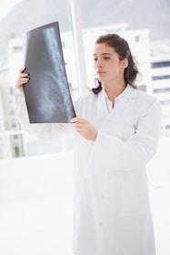 female chiropractor examining a patients x-ray