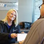 receptionist giving a patient paperwork