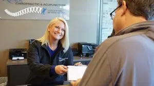 receptionist giving a patient paperwork