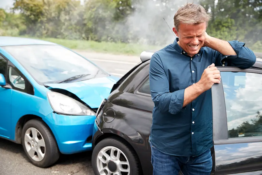 man holding his neck due too an auto injury