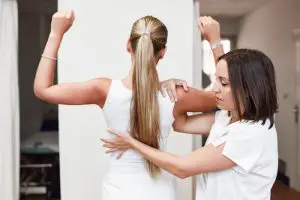 chiropractor stretching female patients upper back