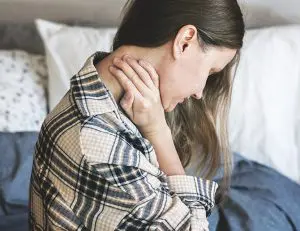 woman holding her neck due to pain