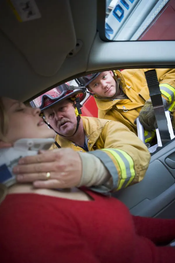 firefighters helping a female wwho had just been in a recent car accident 