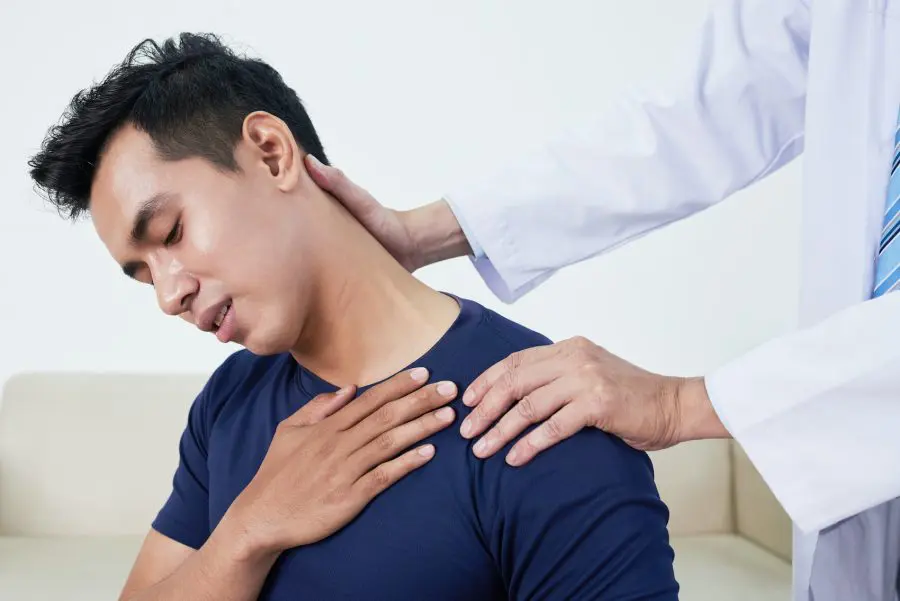 young man having his shoulder stretched due to pain