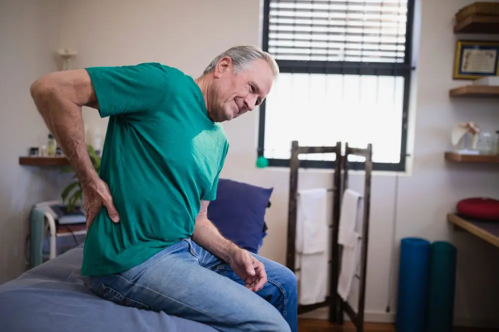 Elderly man holding his side due to pain