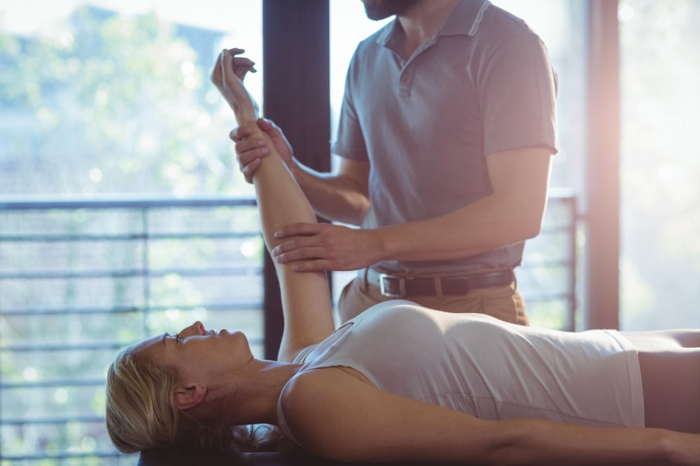 chiropractor examining a patients elbow