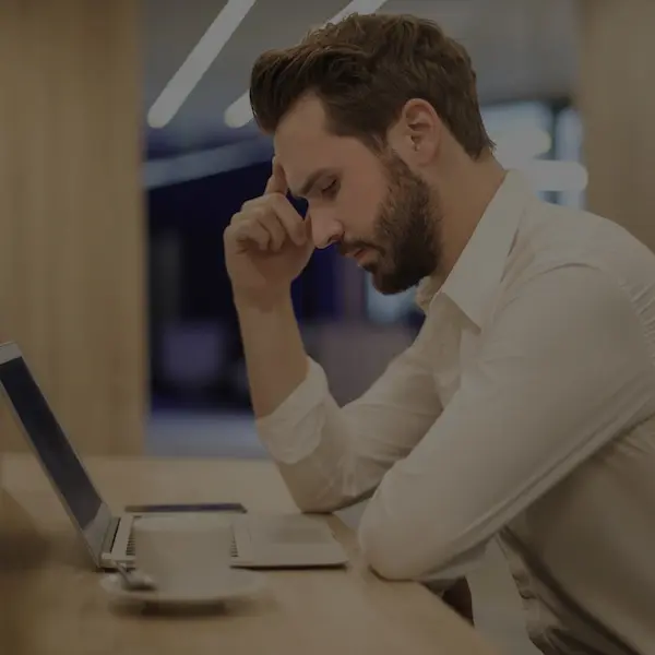 male office worker having a headache while working