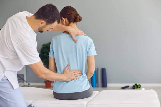 Woman is getting her spine adjusted by a chiropractor
