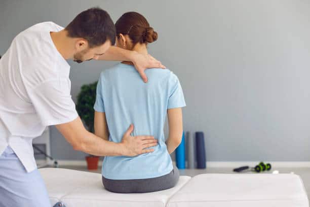 Woman is getting her spine adjusted by a chiropractor 