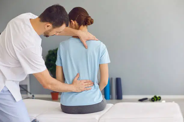 Woman is getting her spine adjusted by a chiropractor 