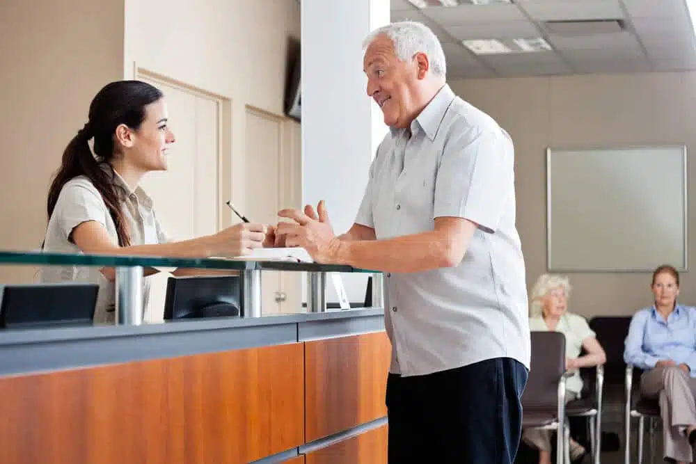 Patient is having a conversation with a receptionist in the clinic.