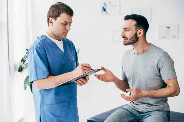 Chiropractor explaining the health insurance information to the patient before the treatment.