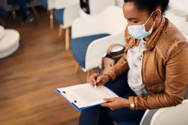 Woman patient filling in her information for the health insurance claim. 