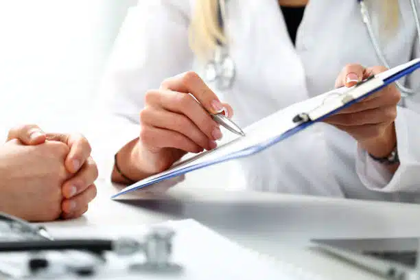 Chiropractor explaining the health insurance information to the patient before the treatment.