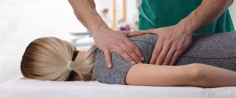 chiropractor adjusting patients back and shoulder blade