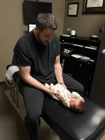 Dr. Kevin Kosak on pediatric chiropractic care performing assessment on baby