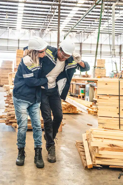 co-worker assisting fellow worker after experiencing workplace injury